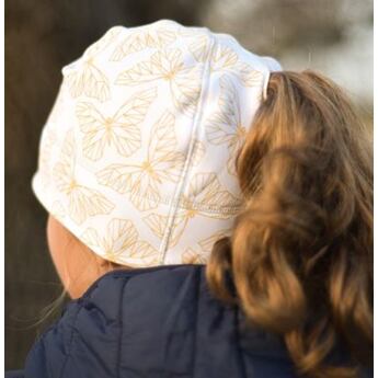 dívka v zimní čepici s otvorem na culík pro douhé vlasy